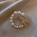 Nahaufnahme einer eleganten Goldbrosche mit Schmetterling, Perlen und funkelnden Strasssteinen - Ring Schmetterling Perle Stil (BH08-Gold)