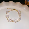 Elegant triple-layer pearl bracelet with gold-tone chain on white ceramic plate. - 46# Bracelet Three-Layer Gold Thin Chain Style / 6mm / Gold Pearl 6mm