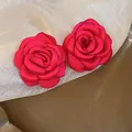 Elegant red fabric rose stud earrings displayed on a white mesh background. - 3D Rose (33#) / Silver Earring Post Style / Rose Red