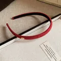 Close-up detail of a red flocked thin headband with elegant gold "Love" charm accent - Red
