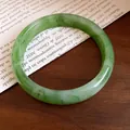 Dettaglio di un braccialetto rigido in resina marmorizzata verde lucida su legno - Grande / Verde Acquerellato