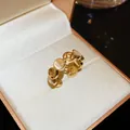 Dettaglio di un anello dorato con motivo a moneta e pietre occhio di gatto bianche in scatola - Stile Occhio di Gatto Moneta Antica