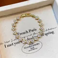 Detailed close-up of a gold-plated clover bracelet pavé-set with shimmering zircons - Gold