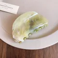 Detail showing the elegant marbled texture of a light green acrylic hair claw clip - Oval Hair Claw / Gray