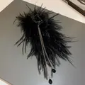 Macro view of elegant black feather hair claw clip with golden tassels and black crystals. - Tassel Feather Black Style 28