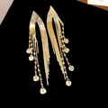 Exquisite detail of 18k gold-plated long tassel earrings with shimmering sequin drops - Gold