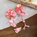 Detailopname van roze chiffon bloemenoorbellen met elegante lange kwastjes voor zomer - Stijl 47 Drielaagse Bloem (HE19995)