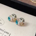 Detailansicht der Seestern- und Muschelohrstecker mit blauen Kristallen und Perlen - Ohrstecker (Mit Silberstift) / Gold-Blau