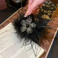 Elegant black feather hair claw clip decorated with a sparkling rhinestone flower motif. - Small Feather Black Style 58