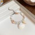 Close-up of a delicate beach-style bracelet with natural shells, pearls and raw stones - White Shell Star Style