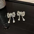 Dettaglio di eleganti orecchini a fiocco in argento con gocce di cristallo lucenti. - Ciondolo Fiocco e Goccia / Argento