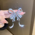 Primo piano dettagliato di un orecchino a fiocco in argento con strass scintillanti - Forma di fiocco / Argento