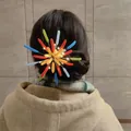 Detailansicht einer bunten, beflockten Feuerwerk-Haarklammer mit leuchtenden LED-Lichtern. - Mehrfarbig/Entenschnabel Clip (Blau-Rot-Grün)