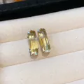 Detailed macro view of elegant rectangular yellow zircon stud earrings in beige jewelry box - Large / Yellow