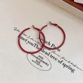 Dettaglio ravvicinato di orecchini a cerchio rossi con perni in argento su tela - Cerchio Tondo (Perno in Argento) / 40mm / Borgogna