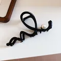Detail shot of an elegant French style black hair claw clip with a decorative pearl - 17# Grip Clamp - Black Wave