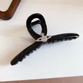 Detail shot of a glossy black hair claw clip featuring a sparkling rhinestone orb ornament. - Planet Saturn Claw / Bright Black