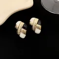 Gros plan de boucles d'oreilles vintage plaquées or avec détails en émail noir et blanc - Patchwork Noir et Blanc à Texture Irrégulière (WE320)