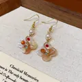 Detailed view of 18K gold plated vintage floral earrings with pearls and zircon - Ear Hook Style (Light Orange) / Gold