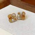 Close-up of vintage flower earrings with 18K gold plating, pearls, and amber zircons - Silver Needle Style (Light Orange) / Gold