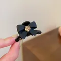 Elegant French style black hair claw clip featuring a matte bow and gold flower center - 37# Claw Clip - Black Camellia Bow