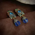 Boucles d'oreilles pendantes dorées vintage avec cristaux bleus facettés et accents émeraude - Clip Bleu Pendant (WE320)