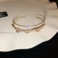 Detailed view of gold zircon bangle with clover flower design and sparkling stones - Four-Leaf Clover Style(HB3853) / Gold