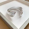 Close-up detail of a shiny pleated geometric open bangle with a metallic silver finish. - Streamlined Pleated Style (4)