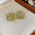 Vue détaillée de boucles d'oreilles fleurs dorées ajourées avec des zircons étincelants - Style Fleur Creuse (HE30635) / Or