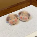 Close-up of cute flocked puppy dog stud earrings with soft fuzzy texture. - Brown and Pink