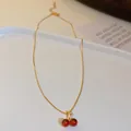Elegant golden clavicle chain necklace featuring a sweet red cherry pendant charm - Red Cherry