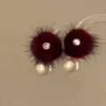 Detail view of burgundy fur ball earrings with sparkling zircon and pearl accents - Real Gold Plated Silver Pin Style / Burgundy