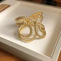 Detailed view of a gold geometric hollow textured open bangle with twisted luxury design - Irregular Wave Style (HB3685) / Gold