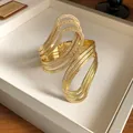 Macro view of gold textured irregular open cuff bracelet with wavy hollow design - Spiral Rope Style (HB3686) / Gold