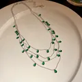 Primer plano detallado de collar multicapa con circonitas verdes en forma de pera joya - Gota de Agua Verde (Collar) / Plateado