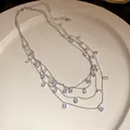 Vista detallada de un elegante collar de varias capas con circonitas en forma de gota - Gota de Agua Transparente (Collar) / Plateado