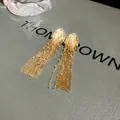 Detailed close-up of elegant long golden fringe earrings with shimmering rhinestones - Rhinestone Decor Style / Gold