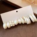 Close-up of elegant acrylic earring set with pearls and geometric shapes on white card - 12-Piece Set / Silver Needle / White