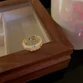 Elegant golden open ring with shimmering cubic zirconia on a wooden jewelry box. - Multi-layer Wave Style (WR271) / Gold