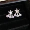 Detail shot of silver star stud earrings with dangling white pearls in a black velvet box. - Star Pendant / Silver