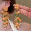 Vibrant orange flower fringe earrings with green seed beads for a fairy-inspired look. - Silver Earring Post Style (151#) / Yellow