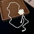 Vue détaillée d'un collier de perles élégant avec une grande rose en tissu blanc sur un plateau. - 双层珍珠项圈 / Blanc