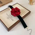 Vue détaillée d'un tour de cou rose rouge avec ruban noir sur un plateau à bijoux - Style 2 / Rouge
