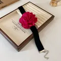 Détail d'un ras du cou fleur rose vintage avec ruban en velours noir sur un plateau - Style 3 / Rose rouge