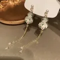 Close-up detail of New Chinese style gourd earrings with pearls and long tassels. - Gourd Tassel Style / Gold-White-Pink