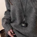 Minimalist long necklace featuring a black leather mini pouch pendant on grey sweater - Style 7-Black