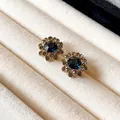 Nahaufnahme von Vintage-Blumenohrringen mit dunkelblauen Zirkonia-Zentren. - 51# Silbernadel-Gold-Blau