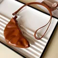 Detailed view of a vintage brown croissant-shaped PU leather coin purse necklace accessory - Brown
