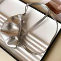 Primer plano del collar monedero de cuero metálico plateado con forma de croissant. - Plateado