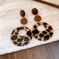 Detailed macro view of vintage leopard print acrylic drop earrings with brown wooden discs - Coffee-Round